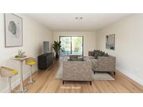 Bright, staged living room features wood floors, bar area, and access to the outside at 8483 Yadkin Cir # C, North Charleston, SC 29418