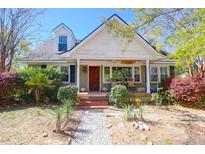 Charming home featuring a welcoming front porch and beautifully landscaped front yard with mature trees and shrubs at 905 Simmons St, Mount Pleasant, SC 29464
