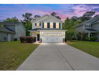 Charming two-story home with well-maintained lawn, a two-car garage and beautiful sunset lighting at 9660 Godwin St, Ladson, SC 29456
