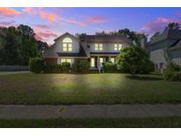 Charming two-story home with mature trees and landscaped yard at dusk at 101 N Warwick Trce, Goose Creek, SC 29445