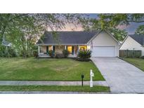 Charming single-story home with attached garage, manicured lawn, and inviting front porch at 109 Red Cypress Dr, Goose Creek, SC 29445