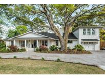 Charming one-story home with a well-manicured lawn, a covered front porch, and beautiful landscaping at 1106 Meadowcroft Ln, Mount Pleasant, SC 29464