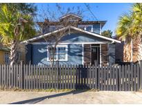 Charming blue two-story home with a black picket fence and mature palm trees at 1153 King St, Charleston, SC 29403