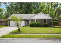 Charming brick home featuring a well-manicured lawn, mature trees, and an attached two-car garage at 119 Savannah Round, Summerville, SC 29485