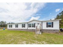 Charming single-story home featuring a white facade, black shutters, and a well-maintained lawn and landscaping at 1330 Whitehouse Rd, Summerville, SC 29486
