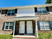 Charming brick townhouse featuring a welcoming front entrance with blue shutters and a 'Welcome' mat at 2040 Rondo St # H, Charleston, SC 29414