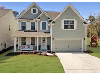 Charming two-story home with a welcoming front porch swing and a two-car garage in a well manicured landscaped yard at 2889 Backman St, Mount Pleasant, SC 29466
