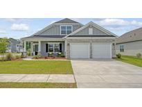 Charming home featuring stone accents, a covered porch, and a two-car garage in a well-manicured community at 317 Fiddleback Dr, Summerville, SC 29486