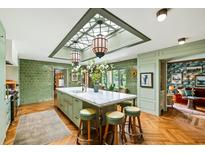 Bright, eat-in kitchen with green tile backsplash, skylight, large island with marble countertop and counter seating at 333 W Confederate Cir, Charleston, SC 29407