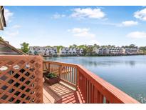 Relaxing deck view overlooking the serene water and surrounding townhouses, providing a peaceful outdoor living space at 4735 Arco Ln, North Charleston, SC 29418
