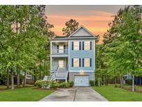 Charming two-story home with a double porch, beautiful trees, nice landscaping, and driveway leading to a garage at 521 Sanders Farm Ln, Wando, SC 29492