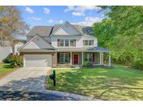 Charming two-story home featuring a brick facade, covered porch, and well-manicured front lawn at 9609 Portal Ct, Summerville, SC 29485