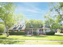 Charming brick home featuring a manicured lawn, mature trees, and a welcoming front porch with gazebo at 100 N Gateshead Xing, Goose Creek, SC 29445