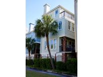 Charming townhouse with a balcony, brick columns and lush, tropical landscaping at 103 Grand Pavilion Blvd, Isle of Palms, SC 29451