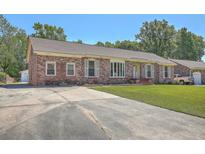 Charming brick home featuring a well-manicured lawn and long driveway, offering curb appeal at 109 Winston Way, Goose Creek, SC 29445