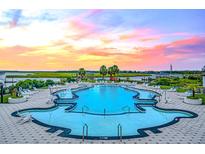 A stunning pool with waterfront views and comfortable lounge chairs perfect for relaxing at 111 Tidewater Way, Charleston, SC 29492