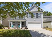 Charming two-story home featuring gray siding, black shutters, a well-manicured lawn, and a two-car garage at 1218 Cosmos Rd, Summerville, SC 29483