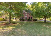 Charming two-story brick home with a well-manicured lawn and mature trees offering curb appeal at 1415 Inland Creek Way, Mount Pleasant, SC 29464