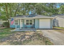 Charming blue single story home with an attached garage and quaint front porch at 184 Tabby Creek Cir, Summerville, SC 29486