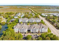 Stunning aerial view of multi-unit complex featuring marsh views, meticulous landscaping, and convenient parking at 1984 Folly Rd # A103, Charleston, SC 29412
