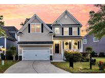Charming two-story home with manicured lawn and a two-car garage during a gorgeous sunset at 2131 Pentland Dr, Charleston, SC 29412
