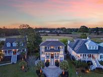Stunning aerial view of luxurious homes with manicured lawns and golf course views during a colorful sunset at 2640 Crooked Stick Ln, Mount Pleasant, SC 29466