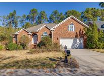 Charming brick home featuring a well-manicured lawn, mature landscaping, and an attached two-car garage at 2800 Waterpointe Cir, Mount Pleasant, SC 29466