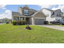 Charming two-story home featuring a well-manicured lawn and attached two-car garage at 2911 Penobscot Dr, North Charleston, SC 29420