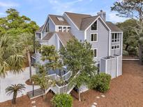 Stately multi-level home with mature landscaping, wood stairs and light blue siding at 3635 Pompano Ct, Seabrook Island, SC 29455