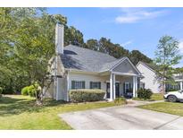Charming home featuring a well-manicured lawn, mature landscaping, and a welcoming front porch at 4807 Habersham Ln, Summerville, SC 29485