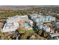 Aerial view of a luxurious resort with pools, lush landscaping, and stunning coastal views at 5802 Palmetto Dr # B-501, Isle of Palms, SC 29451