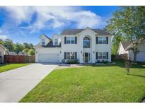 Charming two-story home featuring a well-manicured lawn, attached garage, and a welcoming front facade at 603 Curing Ct, Moncks Corner, SC 29461