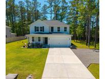 Charming two-story home with a spacious front yard and long driveway nestled among mature trees at 689 W Butternut Rd, Summerville, SC 29483