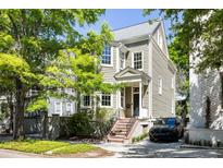 Charming two-story home with landscaped yard, porch, and black car in the driveway at 76 Radcliffe St, Charleston, SC 29403