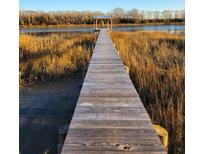 Picturesque wooden dock leading to a gazebo on the water, surrounded by tall marsh grasses at 7997 Doar Rd # C-3, Awendaw, SC 29429