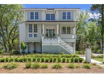 Charming two-story home featuring a welcoming porch, white railings, and beautifully landscaped front yard at 1006 Basin Ln, Johns Island, SC 29455