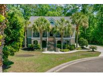 Charming two-story home with a landscaped yard and palm trees, creating a tropical oasis at 105 Aviary Ct, Summerville, SC 29483