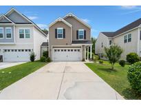Two-story home with neutral siding, black shutters, and a two-car garage with a long driveway and well-maintained landscaping at 121 Dream St, Summerville, SC 29483