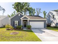 Charming single-story home featuring a two-car garage, manicured lawn, and a welcoming entrance at 1411 Thin Pine Dr, Johns Island, SC 29455