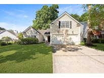 Charming home featuring a well-manicured lawn and a two-car garage at 177 Sugar Magnolia Way, Charleston, SC 29414