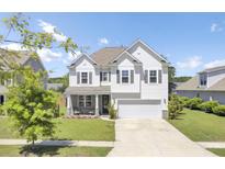 Charming two-story home with a well-manicured lawn, inviting front porch, and a two car garage at 2746 Sunrose Ln, Johns Island, SC 29455