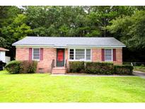 Charming brick home with a well-maintained lawn, complemented by lush greenery at 318 Amy Dr, Goose Creek, SC 29445