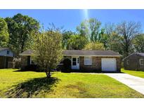 Charming brick home featuring a well-maintained lawn and an attached one car garage at 3215 Bonanza Rd, Charleston, SC 29414