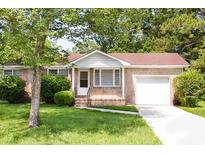 Charming brick home featuring an attached garage, mature landscaping, and a well-maintained front yard at 356 Price St, Goose Creek, SC 29445
