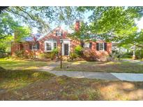 Charming brick home features a well-manicured lawn, a classic brick facade and mature trees at 41 Berkeley Rd, Charleston, SC 29407