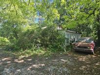 Overgrown front yard with a weathered home and truck, in need of repair and landscaping at 4165 Dorchester Rd, North Charleston, SC 29405