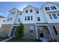 New two-story townhouse boasts white siding, brick facade, and modern architectural design at 5114 Double Eagle Loop, Summerville, SC 29485
