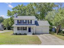 Charming two-story home featuring a covered front porch, attached two car garage, and mature trees at 8363 Water Ash Way, North Charleston, SC 29420