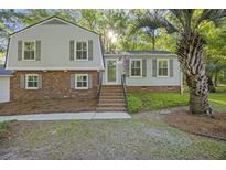 Charming home featuring brick accents, light gray siding, green shutters, and a well manicured yard at 104 Huntington Cir, Summerville, SC 29485