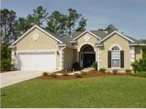 Charming single-story home with a well-manicured lawn, two-car garage, and beautiful landscaping at 1409 Endicot Way, Mount Pleasant, SC 29466